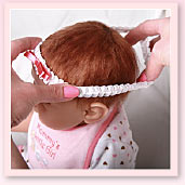 Ashton-Drake Galleries baby doll headband application tip: slip the headband on your baby doll, starting at the front of the head