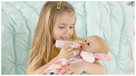 So Truly Mine doll photo gallery: a young girl feeding a So Truly Mine baby doll with a baby bottle accessory